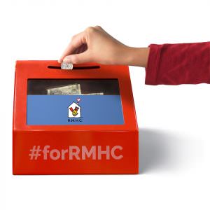 Hand putting coin in RMHC donation box