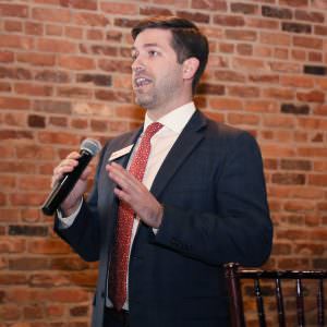 Man in suit speaking into microphone