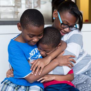 Two brothers and sister hugging