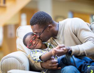 Father kissing son on cheek
