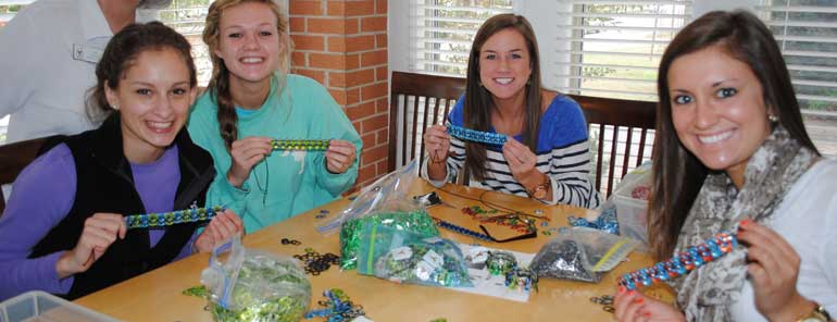 Four girls making pop tab bracelets